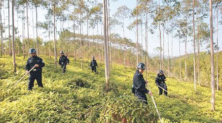 警方手持棍棒上山搜捕兇案疑犯。（互聯網圖片）