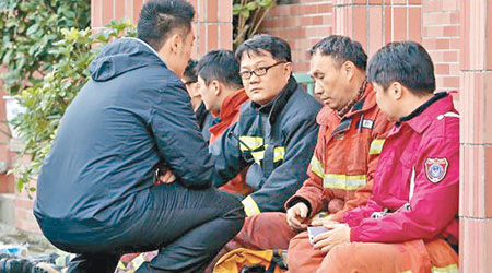 一眾消防員為同袍殉職落寞悲傷。（互聯網圖片）
