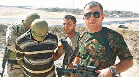阿卜杜拉（右）返鄉參戰後，擄獲IS分子（左二）。（互聯網圖片）