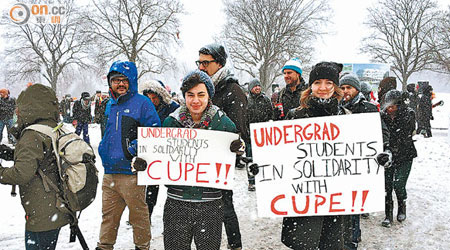 有大學生手持標語，支持導師爭取加薪。（本報加拿大傳真）