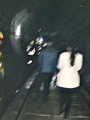 乘客在隧道內摸黑徒步到附近月台。（互聯網圖片）