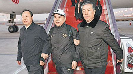 王國強（中）去年回國自首，抵達北京首都機場時被押下機。（互聯網圖片）
