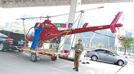 一架紅色小型直升機在加油站入油。（互聯網圖片）