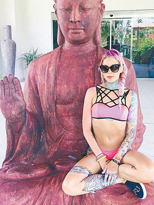 莉安娜身穿比堅尼坐在佛像大腿上拍照，惹來死亡恐嚇。（互聯網圖片）