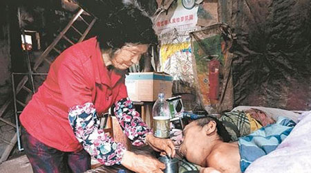 莊婆婆照顧癱瘓的蔡某。（互聯網圖片）