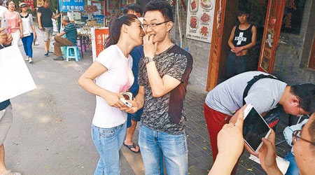 煙民獲美女邀吻，表情趣怪。（互聯網圖片）