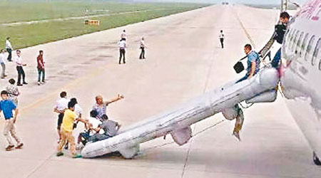 有乘客沿逃生滑梯離開機艙。（互聯網圖片）
