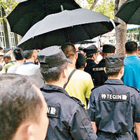 便衣人員開傘阻礙現場記者拍攝。（互聯網圖片）