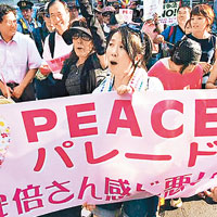 一名女示威者拉着寫有和平字句的橫額。（互聯網圖片）