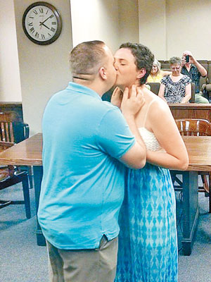 二人在註冊後即場擁吻。（互聯網圖片）