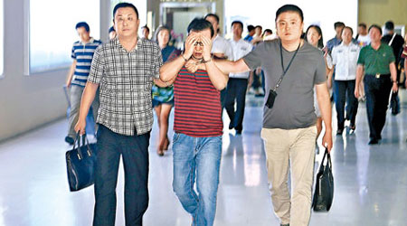 王博（中）被黑龍江警方從菲律賓押解回國。（中新社圖片）