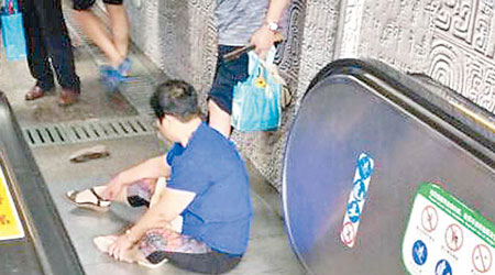 上海<br>受傷婦人坐在地上等候救援。（互聯網圖片）