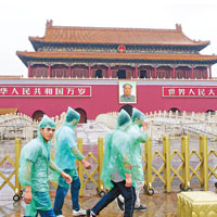 昨日北京曾有降雨，天安門廣場上有行人披上雨衣。（中新社圖片）