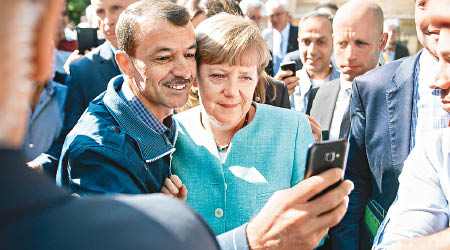 難民與默克爾（前右）貼臉自拍。（互聯網圖片）
