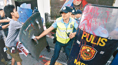 學生衝破警方防線，向美國駐馬尼拉的大使館淋紅漆。