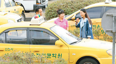 中國學生（右）與翻譯（中）在駕駛學院內一起聽課。（互聯網圖片）