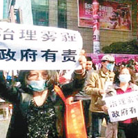 馮紅蓮（左）早前曾到西安市政府門前舉牌抗議霧霾問題。