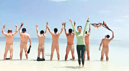 照片拍下七名男子在沙灘上全裸，一名中國女遊客則面向鏡頭展示勝利手勢。（互聯網圖片）