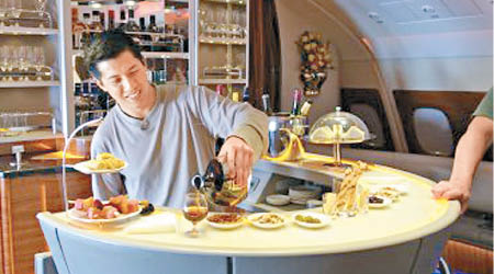 美國作家薩姆‧黃在頭等艙享受美酒佳餚。（互聯網圖片）