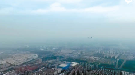 無人機拍攝時，一架噴氣式戰鬥機經過。（電視畫面）
