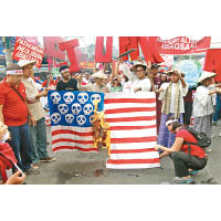 反美示威者燃燒自製的「美國國旗」。（中新社圖片）