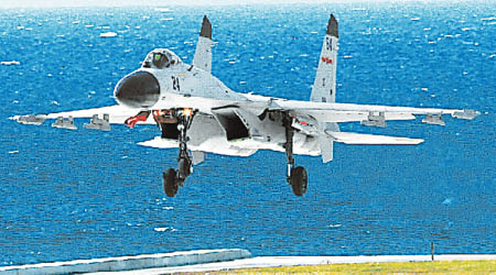 官媒刊登殲11B戰機前往南海島礁展開訓練的照片。（互聯網圖片）