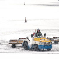 機場地勤人員加緊清理跑道上的積雪。（互聯網圖片）