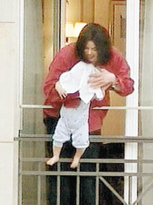 米高積遜生前曾把當時只有半歲大兒子凌空伸出露台外。（資料圖片）