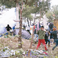 滯留在邊境的移民紛紛躲避馬其頓警方發射的催淚彈。