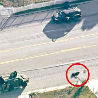 一名槍手遭警員擊斃，伏屍街頭（紅圈示），上方為其汽車停在路邊。（互聯網圖片）