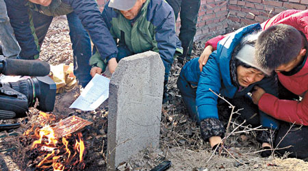 呼格勒圖家人在其墳前燒再審判決書複印件。（資料圖片）