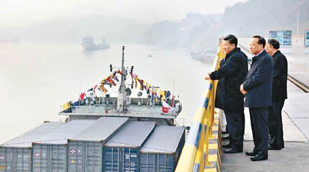 習近平（左）在當地官員陪同下察看正在作業的貨櫃船。（互聯網圖片）