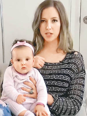 湯姆森抱着女兒，憶述在機上餵母乳被歧視的經歷。（互聯網圖片）