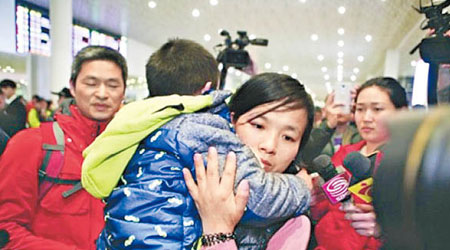 警方將被拐騙獲救的丁源帶回深圳，其母立即上前將他抱起。（互聯網圖片）