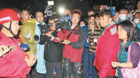 搜救隊指揮劉永森（左）向受災家屬解釋撤退原因。