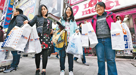 中國遊客在東京免稅店購得一袋袋「戰利品」。