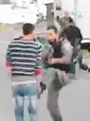 一名以色列警員踢向巴人。