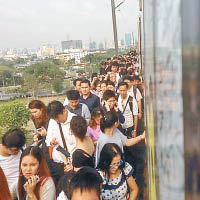 大批乘客沿路軌步行至車站。