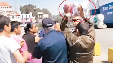 一名男子舉起嬰兒（紅圈示）欲掟向警員。（互聯網圖片）