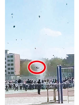 網傳塵捲風把一名小學生（紅圈示）捲上半空。（互聯網圖片）