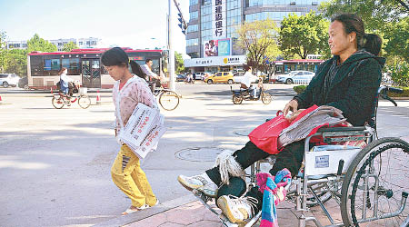 倩倩與坐輪椅的母親一同出外賣報紙。（互聯網圖片）