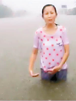 河南有電視台女記者在洪水中報道，衣服全濕，透出小背心。