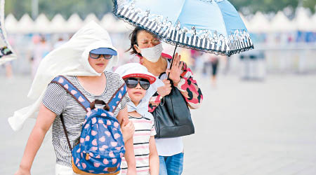 北京天氣酷熱，市民出門時都做足防護措施。