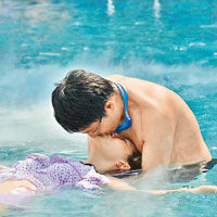 情侶在泳池內表演花式接吻。
