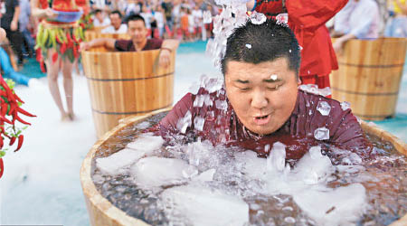 杭州「浸冰桶吃辣椒」參加者被當頭倒下冰水，感受冰火兩重天。（互聯網圖片）