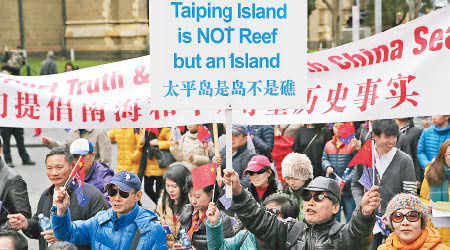 墨爾本的遊行隊伍高舉寫有「太平島是島不是礁」字樣的標語。（中新社圖片）