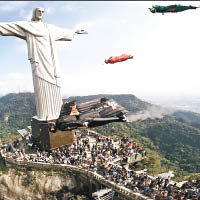 為迎接奧運，來自巴西、美國及委內瑞拉的五名滑翔飛行運動員，身穿代表奧運五環顏色的飛行服，飛越里約科科瓦多山的耶穌像。（中新社圖片）
