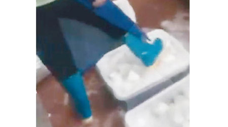 有員工用水鞋鞋底輕掃餐具「清洗」。（電視畫面）