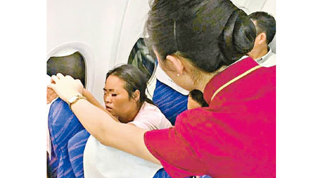 空姐慰問咳血的女乘客（左）。