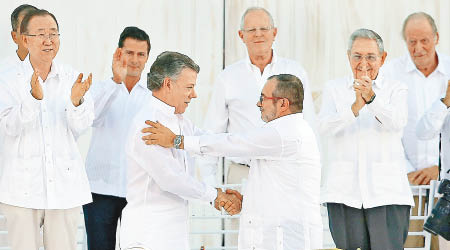 桑托斯（前左）與季莫申科（前右）握手。聯合國秘書長潘基文（左一）及古巴總統勞爾‧卡斯特羅（右二）在場見證。
